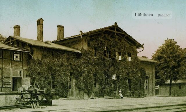 Historische Postkarte des Bahnhofs Lübtheen, efeubewachsenes Backsteingebäude an den Gleisen